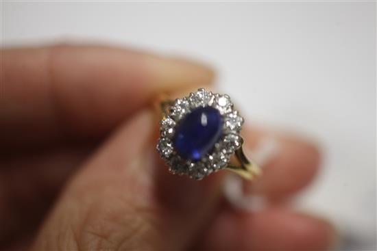 A cabochon sapphire and diamond cluster ring, size N.